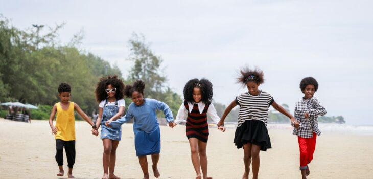 Funny vacation. Children or kids playing and romping together at the beach on holiday.